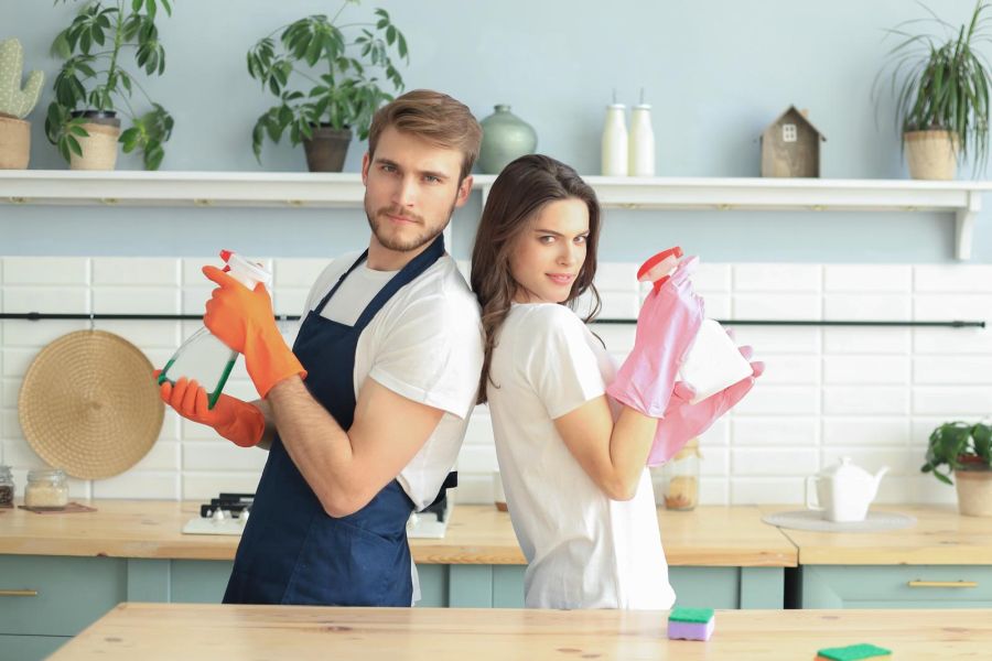 a couple holding cleaning chemicals for interiors 